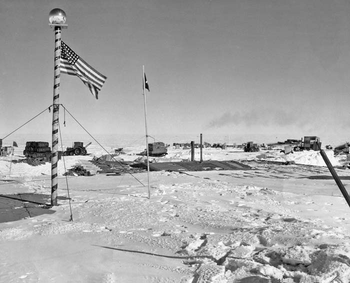 The striped flagpole on top of the garage roof